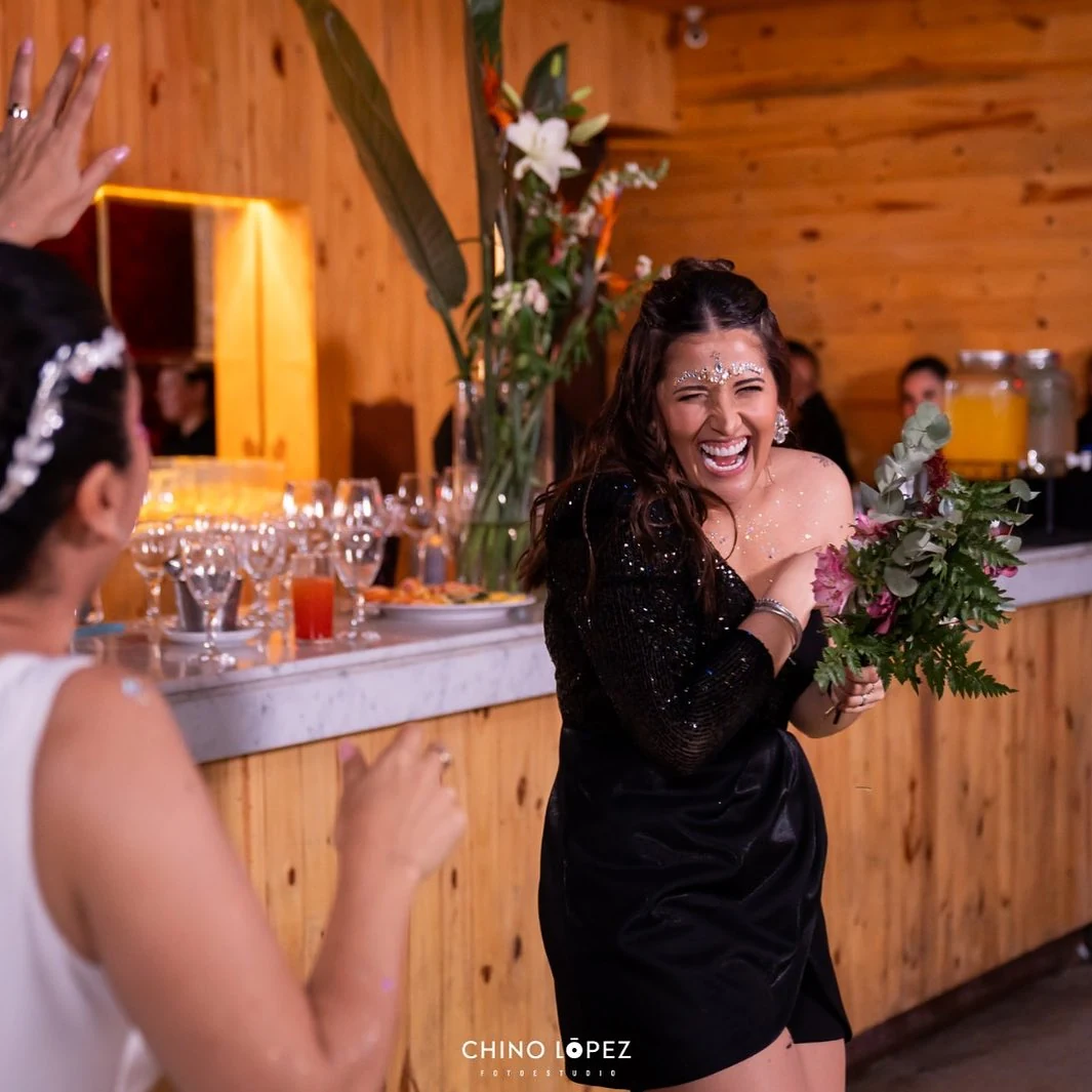 Invitada brindando en la barra de madera de Espacio Madero; fotografía con crédito original